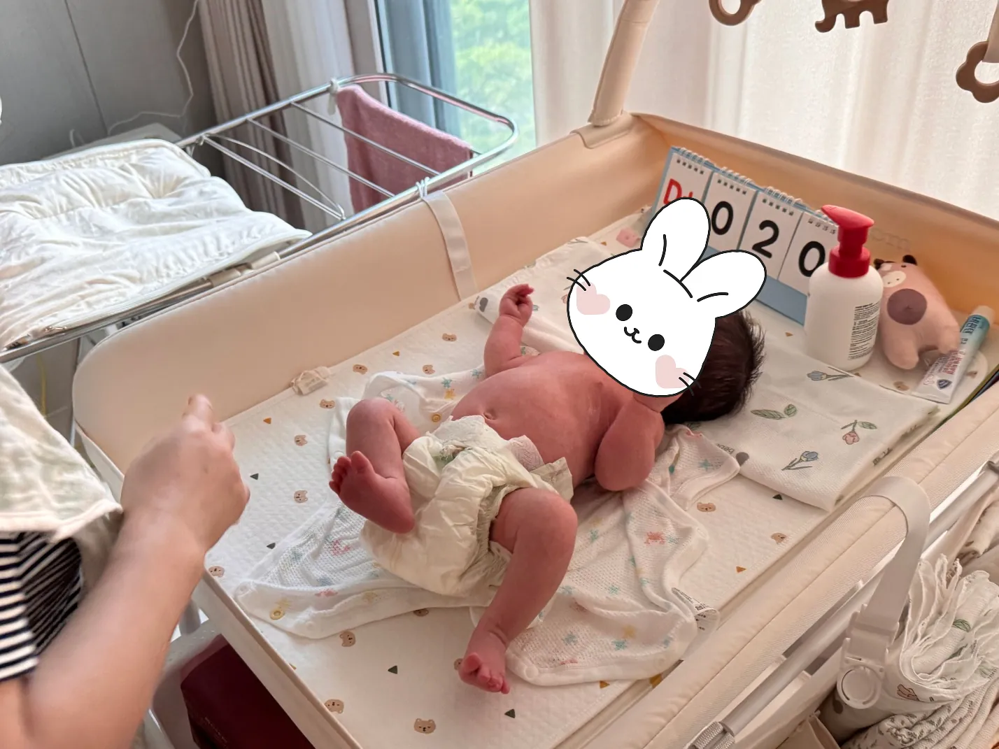 기저귀 교환대에 누워 있는 신생아