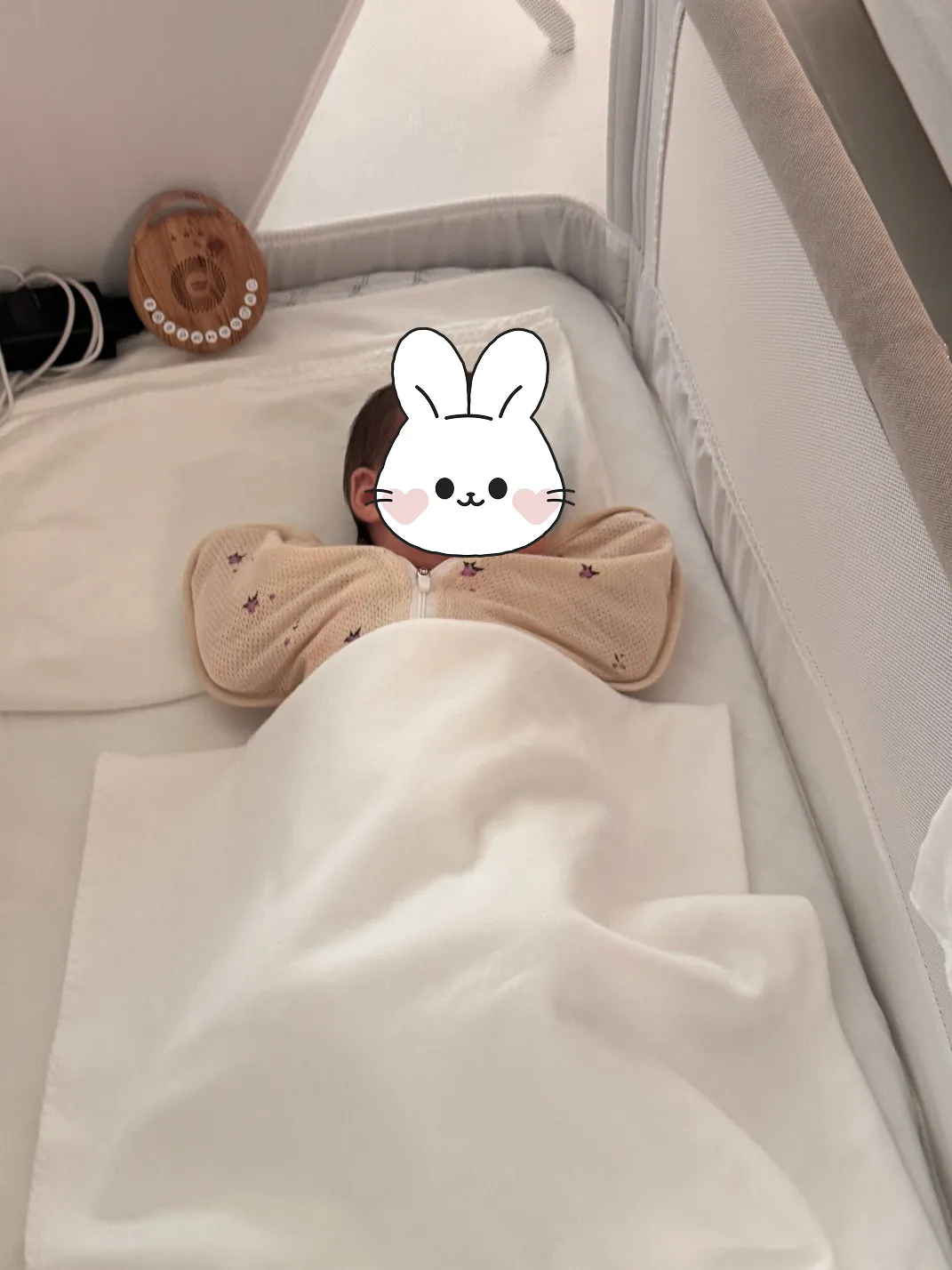 아기 침대에서 이불을 덮고 누워 있는 신생아